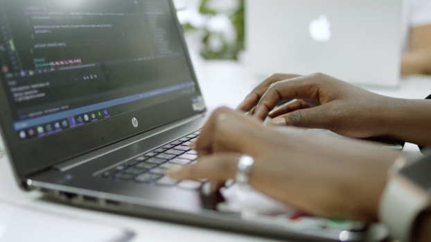 Software engineer typing code on laptop