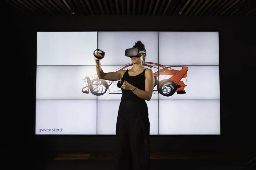 Female design engineer sketches car designs in 3D VR