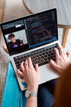 Female software engineer codes on a laptop