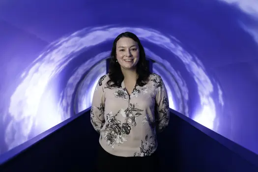 Michelle Hicks, female civil engineer, smiles at the camera in a theme park