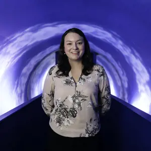 Michelle Hicks, female civil engineer, smiles at the camera in a theme park