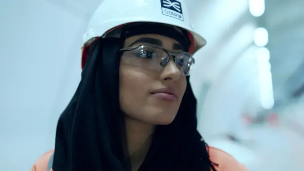 Female civil engineer, stands in well-lit underground tunnel