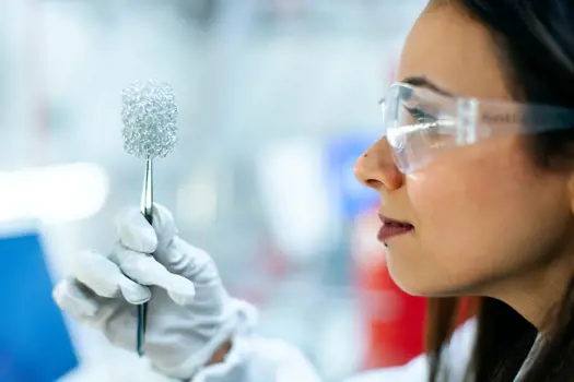 Female chemical engineer, holds up invention in laboratory
