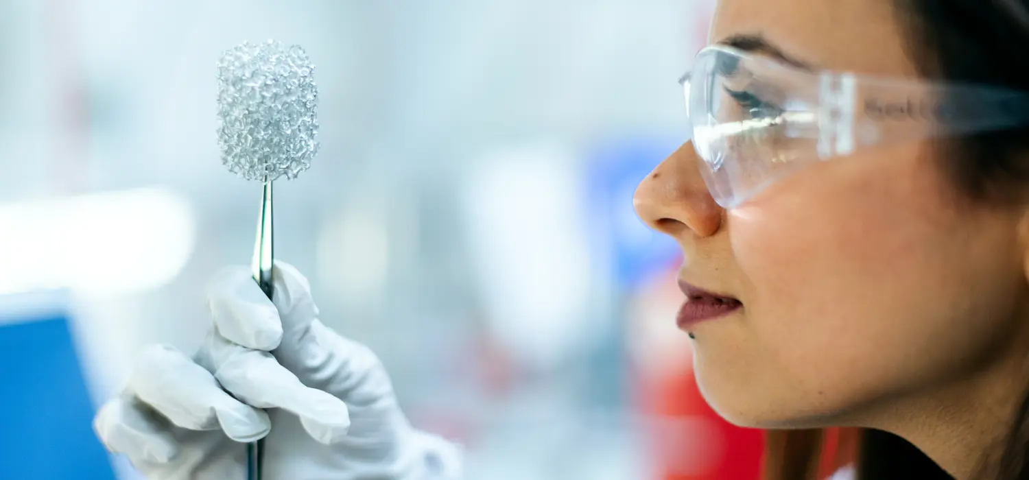 Female chemical engineer, holds up invention in laboratory