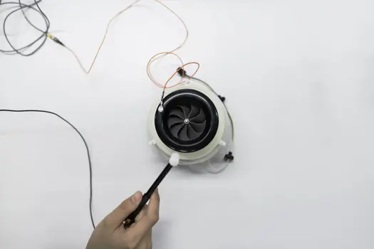 Female noise and acoustics engineer tests product in a workshop