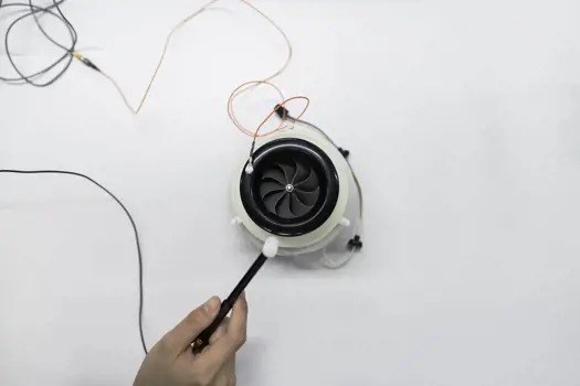 Female noise and acoustics engineer tests product in a workshop