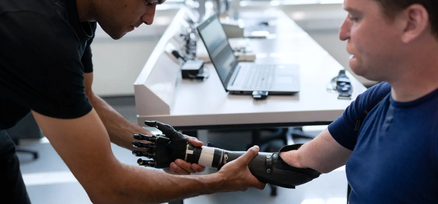 Robotics engineer fitting a prosthetic arm