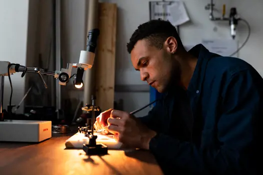 Male mechanical engineer solders a circuit board