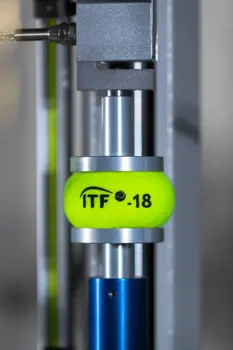 Tennis ball being tested in machinery