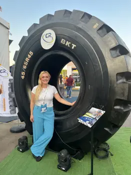 Kim Everitt, transport systems engineer, stood by large HGV tyre.