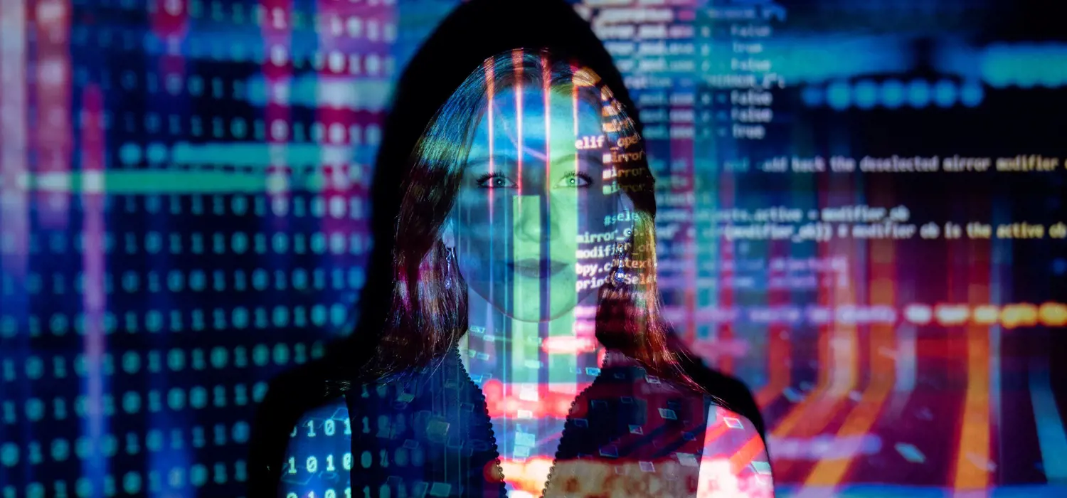 Female software engineer stands with code projected on a screen