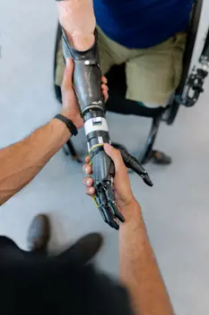 Male mechanical engineer helps with prosthetic arm
