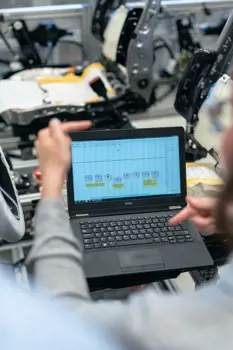 Female electronics and quality engineer uses a laptop in workshop