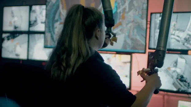 Female apprentice mechanical engineer uses robot