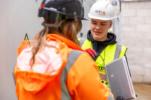 Apprentice engineer talking with colleagues 