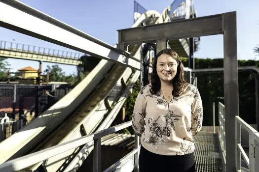 Female civil engineer stands next to a roller-coaster